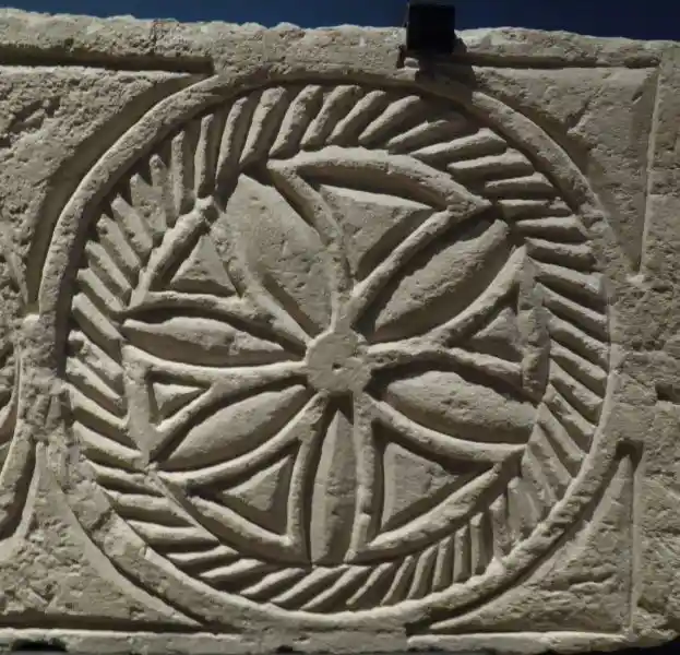 Flower-like inside a circle with rays on a stone
